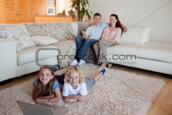 Siblings with laptop on the floor