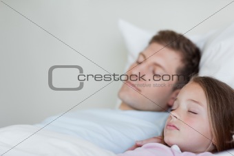 Side view of father and daughter asleep