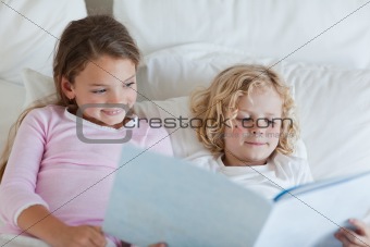 Brother and sister reading bed time story