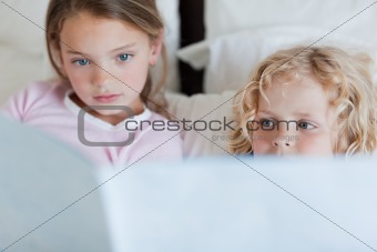 Siblings reading bed time story