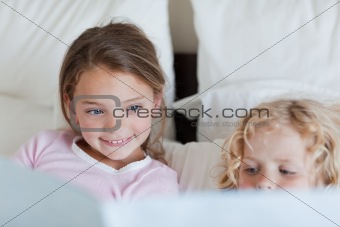 Girl reading a fairy tale for her brother