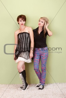 Two frustrated punk teen girls look to the camera