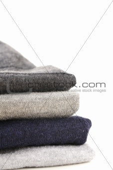A pile of warm knitted gray sweaters
