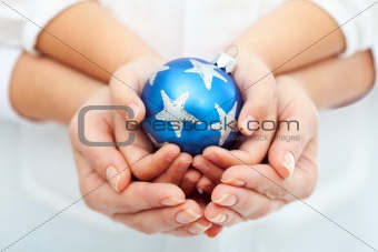 Adult and child hands holding christmas bauble