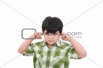 Photo of a boy with his fingers in his ears. 