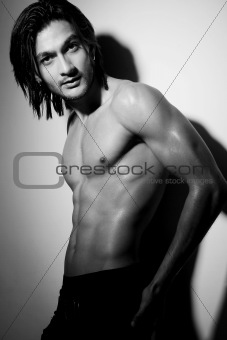 Portrait of a young Indian shirtless male posing with hand on hip.