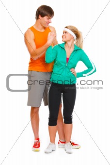 Happy male athlete and fitness young woman handshaking isolated on white
