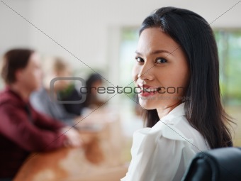 businesspeople talking in meeting room and woman smiling