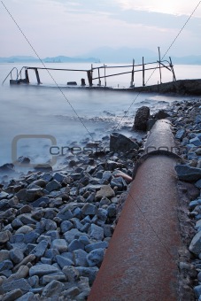 old metal pipe and road to sea