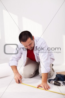 Casual man laying isolation foam beneat flooring