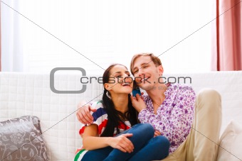 Smiling young couple speaking phone together
