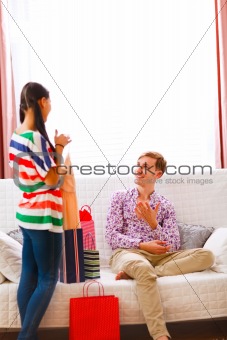 Young man helping her girlfriend to choose dress
