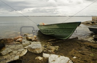 Green fishing boat on seacoast