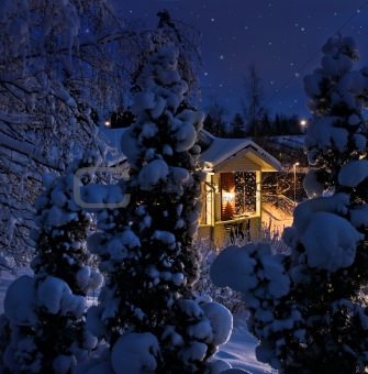Illuminated house on snowy Christmas evening