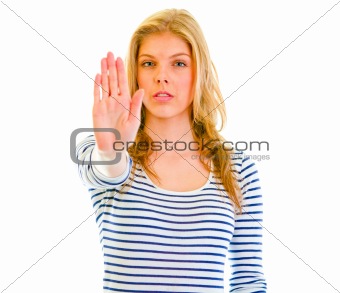 Portrait of serious teen girl showing stop gesture
