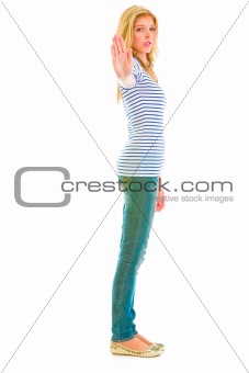 Full length portrait of serious teen girl showing stop gesture
