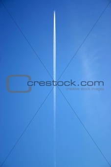 A jet flying overhead with jet trails.