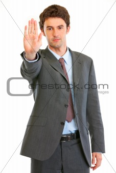 Serious modern businessman showing stop gesture
