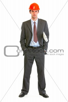 Full length portrait of serious architect holding building plans in hand
