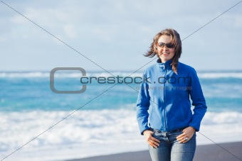 Young woman walking near blue sea.