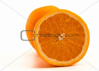 One half of orange with another whole orange beyond. On white.