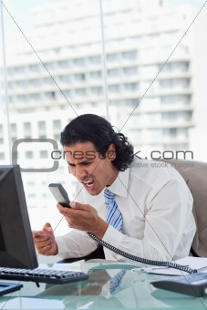 Portrait of a angry businessman shouting at his handset