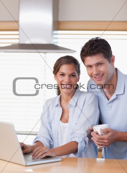 Portrait of a couple using a laptop while having coffee