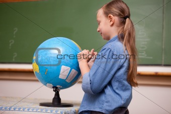 Schoolgirl looking at a globe