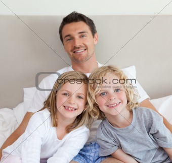 Father sitting on bed with his children