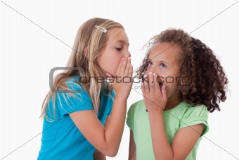 Young girl whispering a secret to her friend