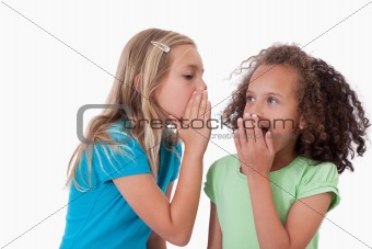 Cute girl whispering a secret to her friend