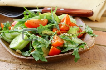 salad with arugula and cherry tomatoes on a wooden plate