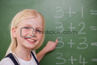 Blonde schoolgirl pointing at something