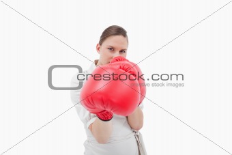 Young businesswoman boxing