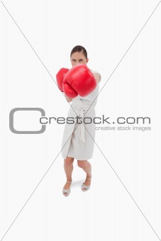 Portrait of a serious businesswoman punching someone