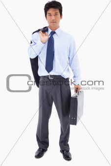 Portrait of a businessman holding a briefcase and his jacket over his shoulder