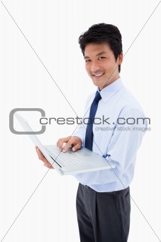 Portrait of a smiling businessman using a laptop