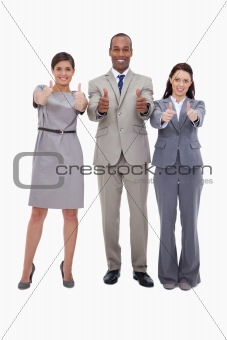 Smiling businessteam giving thumbs up