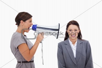 Businesswoman using megaphone to yell at colleague