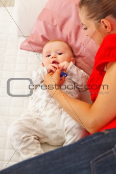 Baby playing with mother on sofa