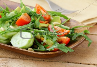 salad with arugula and cherry tomatoes on a wooden plate