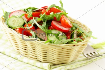 salad with arugula and cherry tomatoes on a wooden plate
