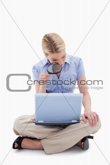 Woman using magnifier to look at her laptop