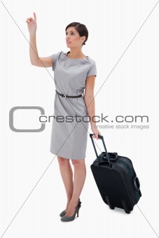 Woman with wheely bag calling a taxi