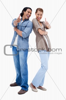 Smiling young couple giving thumbs up