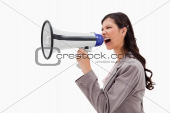 Side view of angry businesswoman shouting through megaphone
