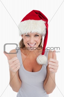 Portrait of a woman with the thumbs up and a Christmas hat