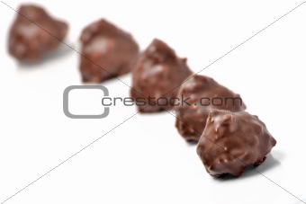 Delicious chocolates and nuts on white background