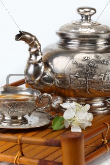 green tea in the cup, teapot, flowers