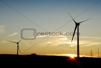 Silhouette of Two Wind Turbines at Dawn. UK